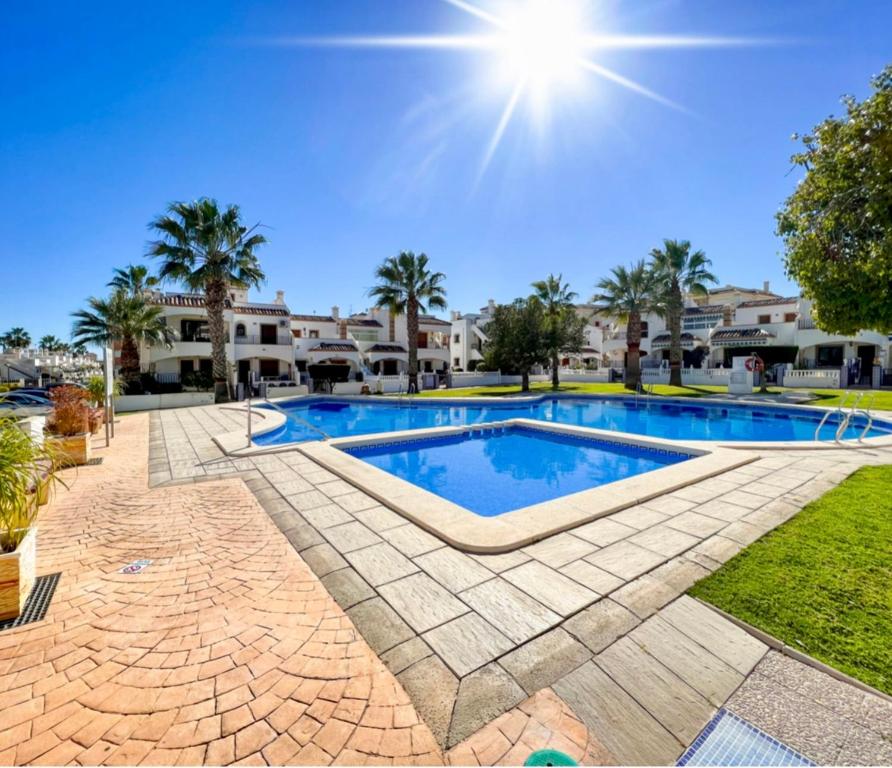 una piscina en un patio con árboles y edificios en Casa Domenico, en Alicante