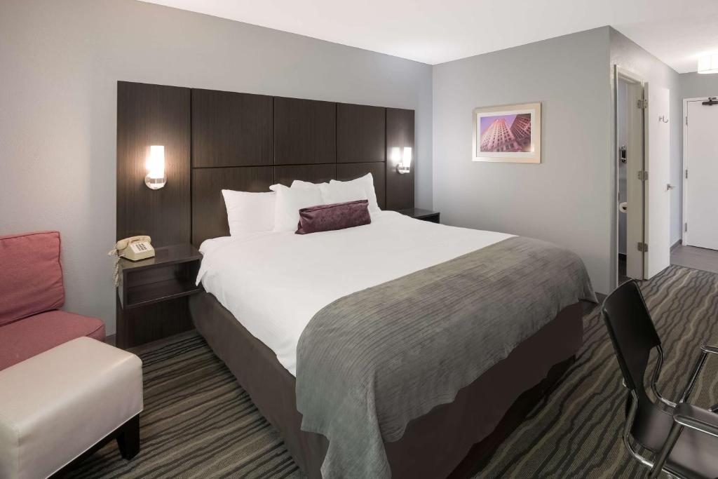 una habitación de hotel con una cama grande y una silla en Best Western Riverside Inn en Danville