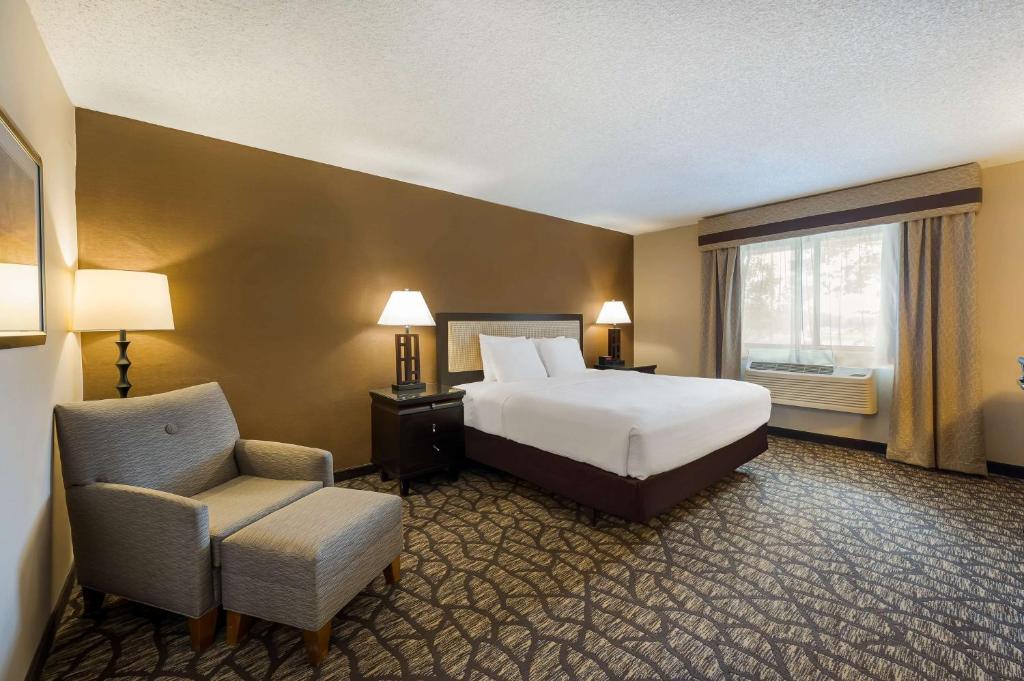 a hotel room with a bed and a chair at Best Western Detroit Livonia in Livonia