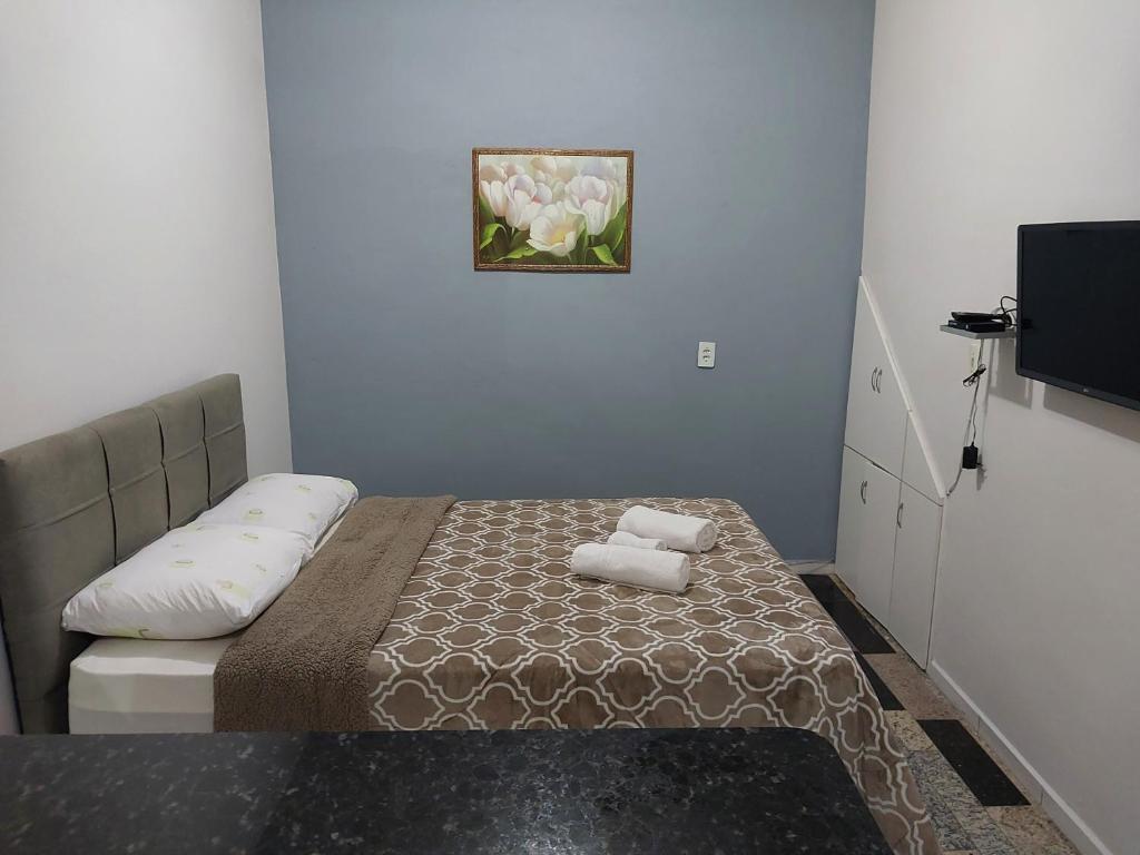 - une petite chambre avec un lit et 2 serviettes dans l'établissement Kitnet da Sidi, à São Thomé das Letras