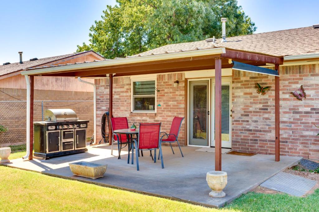 um pátio com um telhado, uma mesa e cadeiras em Cozy Oklahoma Retreat with Covered Patio and Gas Grill em Mustang