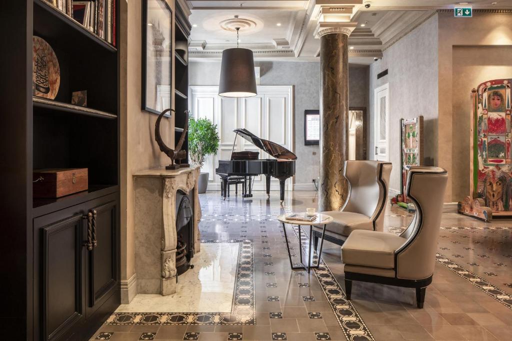 a living room with a fireplace and a piano at The Bank Hotel Istanbul, a Member of Design Hotels in Istanbul
