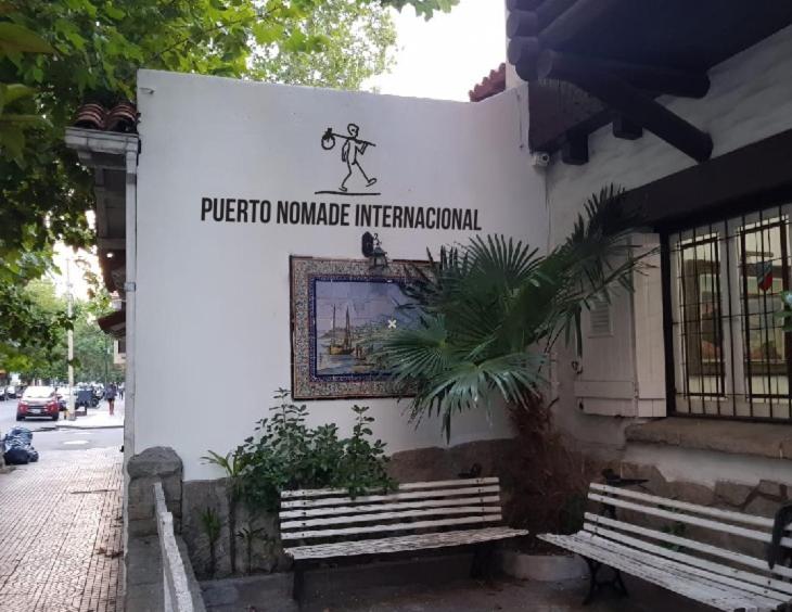 una señal en el lateral de un edificio con un banco en Puerto Nómade Hostel Internacional en Mar del Plata