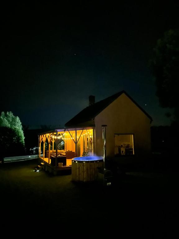 ein nachts beleuchtetes Haus mit Licht in der Unterkunft Baciki 61- domek przy lesie in Baciki Dalsze