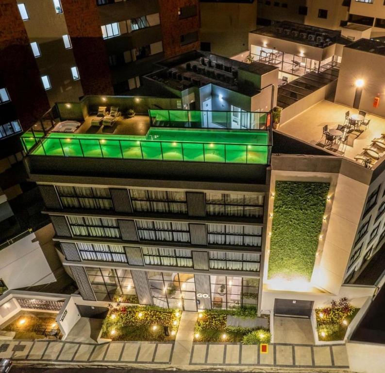 uma vista superior de um edifício com luzes verdes em Apartamentos Centro Poços de Caldas em Poços de Caldas