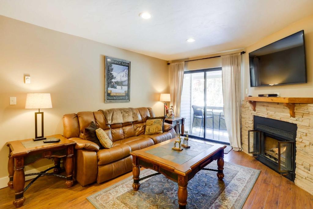a living room with a leather couch and a fireplace at Chic and Cozy Breck Condo Ski-InandSki-Out at Peak 8! in Breckenridge