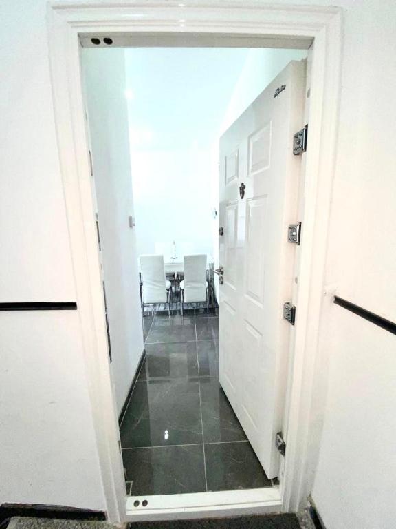 a hallway with a room with a table and white doors at appartement douvres in Brussels