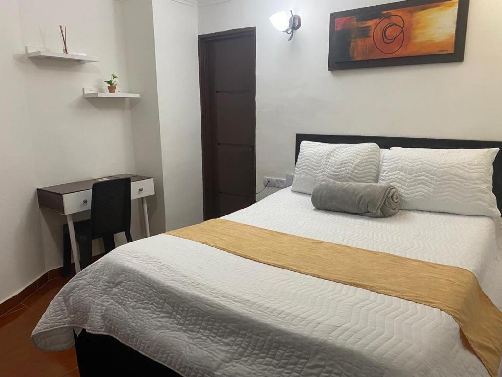 1 dormitorio con 1 cama, escritorio y en Hotel Avenida 3 Real en el norte de Cali, en Cali