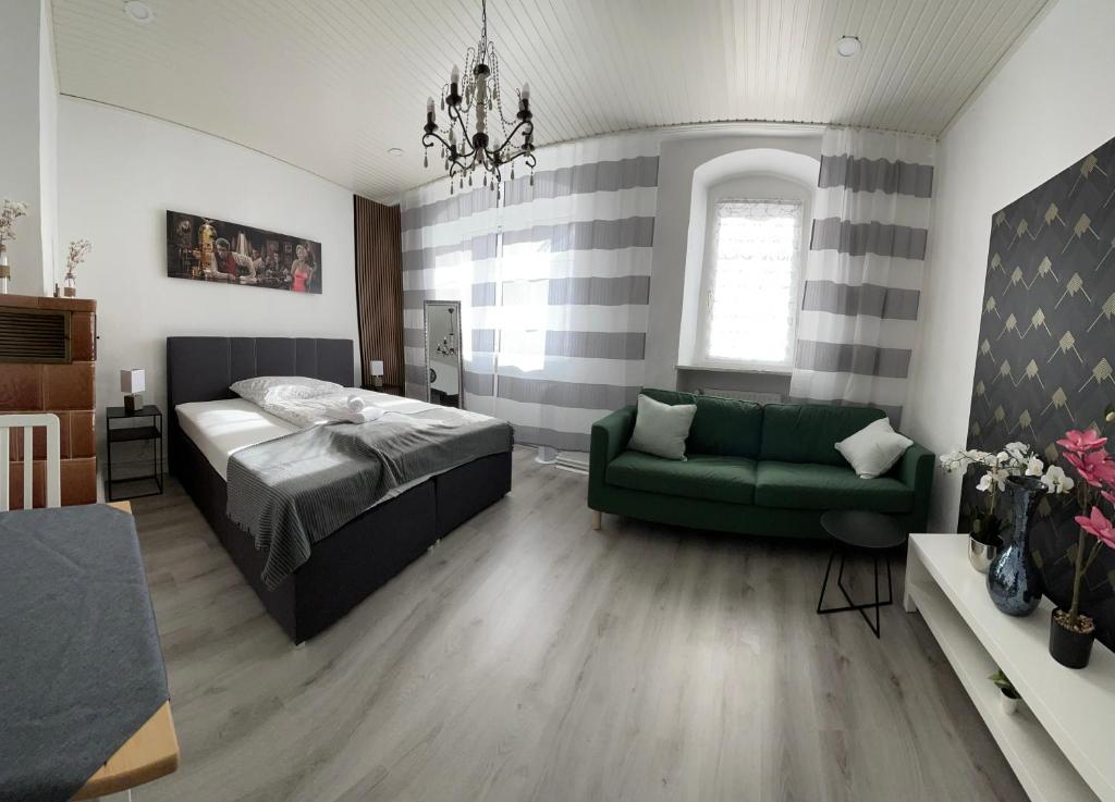 1 dormitorio con 1 cama y 1 sofá verde en Historisches Haus am Fuße der Festung Ehrenbreitstein am schönen Rhein, en Coblenza