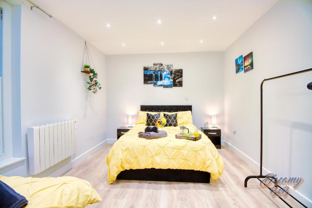 a bedroom with a bed with a yellow bedspread at Amazing place in Finsbury Park in London