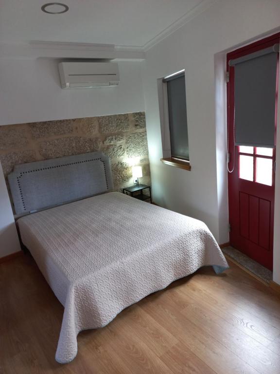 a bedroom with a bed and a red door at TORREÃO HOUSE in Guarda