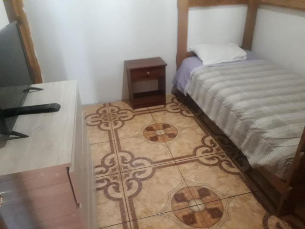 a small bedroom with a bed and a table at Residencial familiar El Valle in Calama