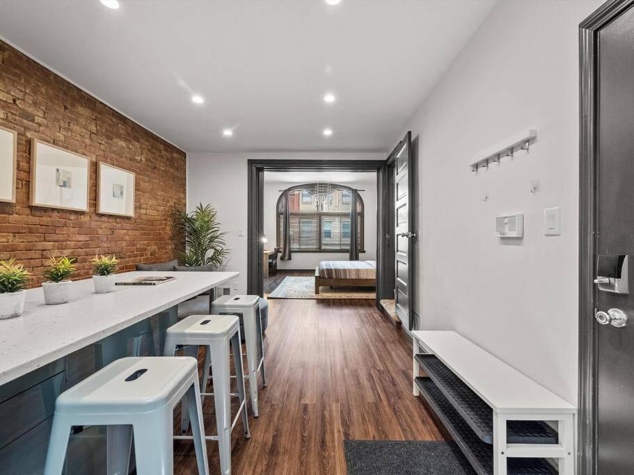 a kitchen with white counter tops and stools at Luxury and Stylish 2Bedroom Apartment on Carson, South Flats, Pittsburgh in Pittsburgh