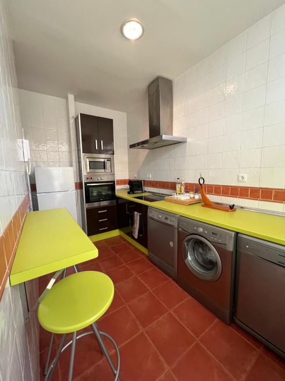 a kitchen with a green counter and a washing machine at Apartamentos Sevilla Deluxe Rosales in Los Rosales
