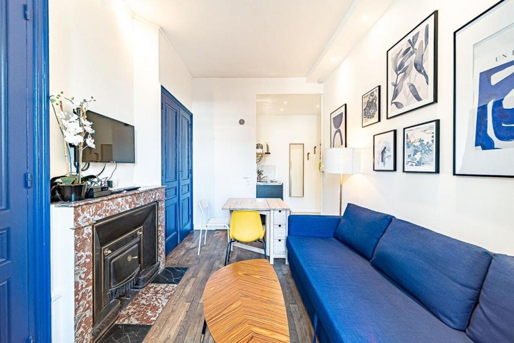 a living room with a blue couch and a fireplace at Le petit Charlemagne- Studio Rénové -Perrache in Lyon
