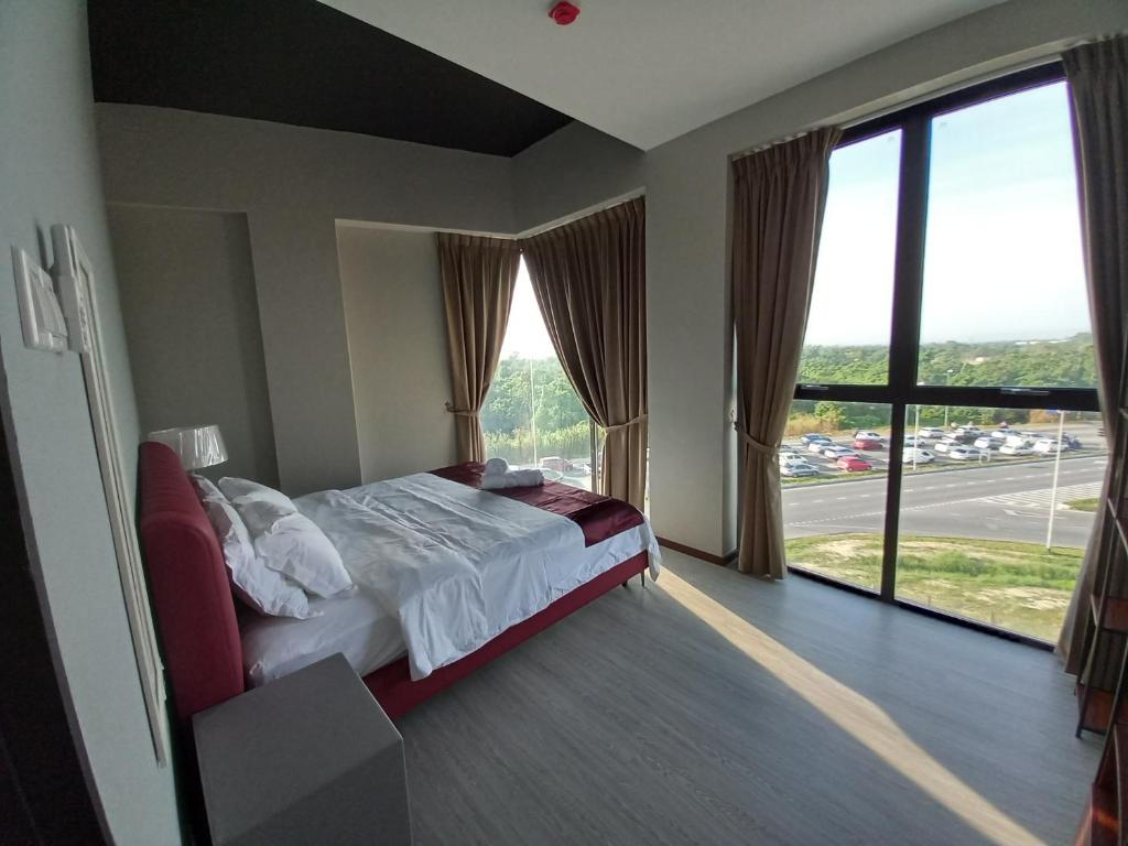 - une chambre avec un lit et une grande fenêtre dans l'établissement KAN JIA, à Miri
