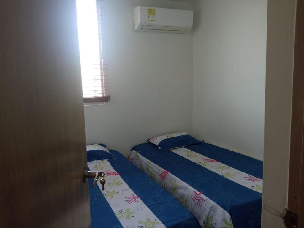 a bedroom with two beds and a window at Cómodo apartamento cerca al mar in Coveñas