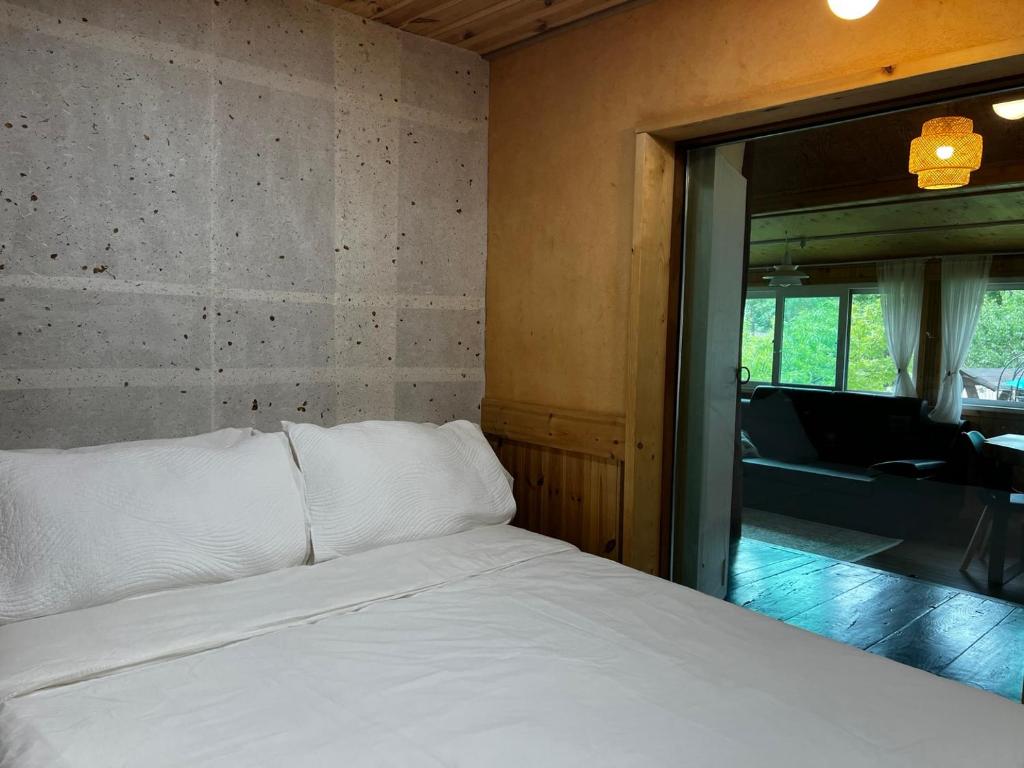 ein Schlafzimmer mit einem weißen Bett und einem großen Fenster in der Unterkunft Chef's Garden 