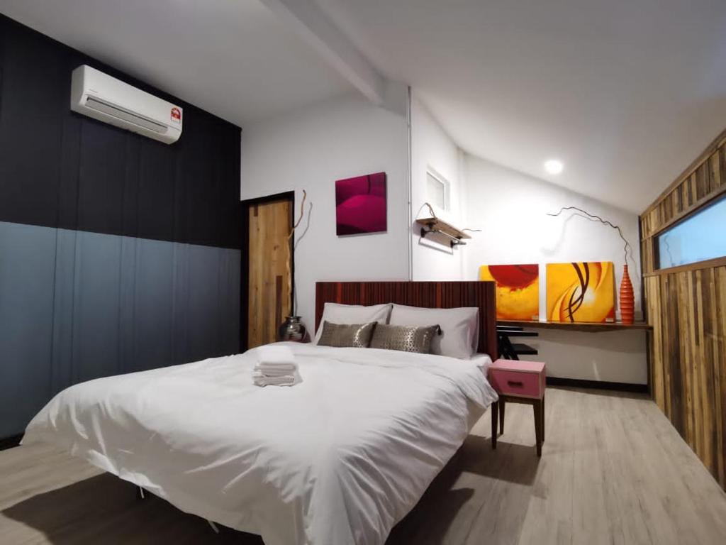 a bedroom with a large white bed and a window at 7 Wooden Lodge Ipoh City in Ipoh