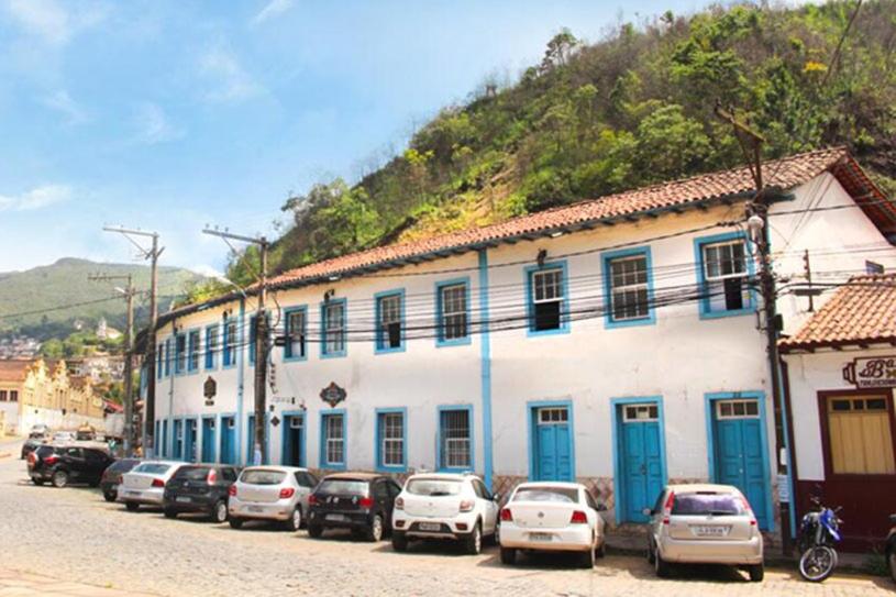 um grupo de carros estacionados em frente a um edifício em Hotel Nossa Senhora Aparecida em Ouro Preto