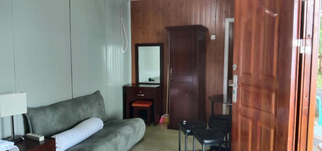 a living room with a couch and a mirror at Melbyls Hills Resort in Tomohon