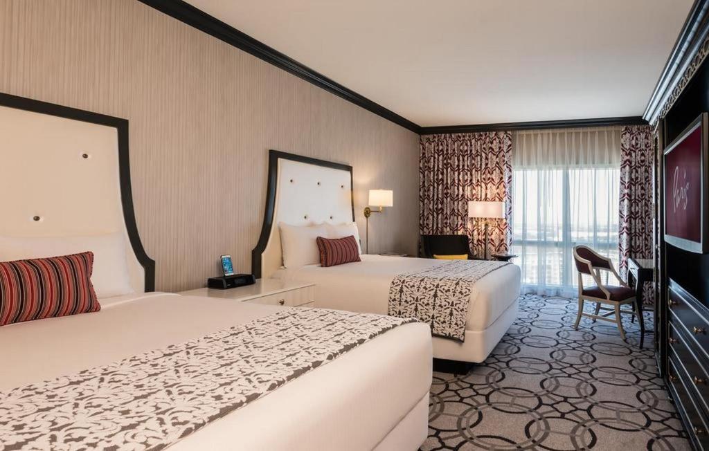 a hotel room with two beds and a television at Attractive Unit by Paris Casino Heart of Strip Las Vegas in Las Vegas