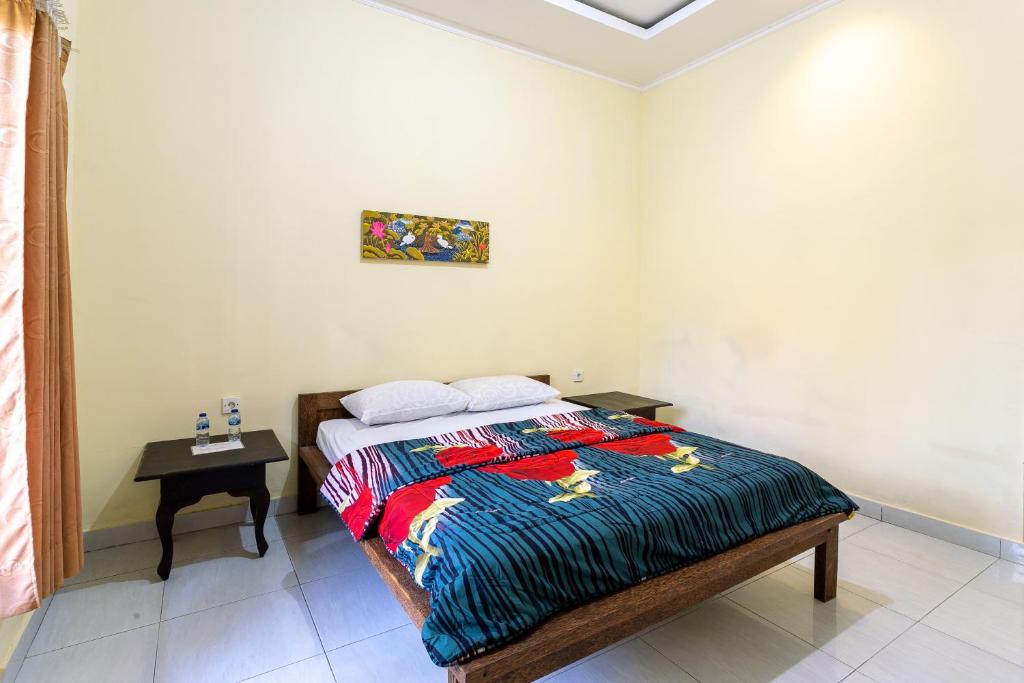 a bedroom with a bed and a table in it at Jero Harum Homestay in Krambitan