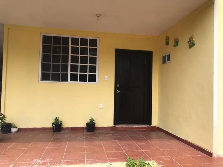 una puerta negra en una pared amarilla con macetas en VILLAS EL MIRADOR, en Tamasopo