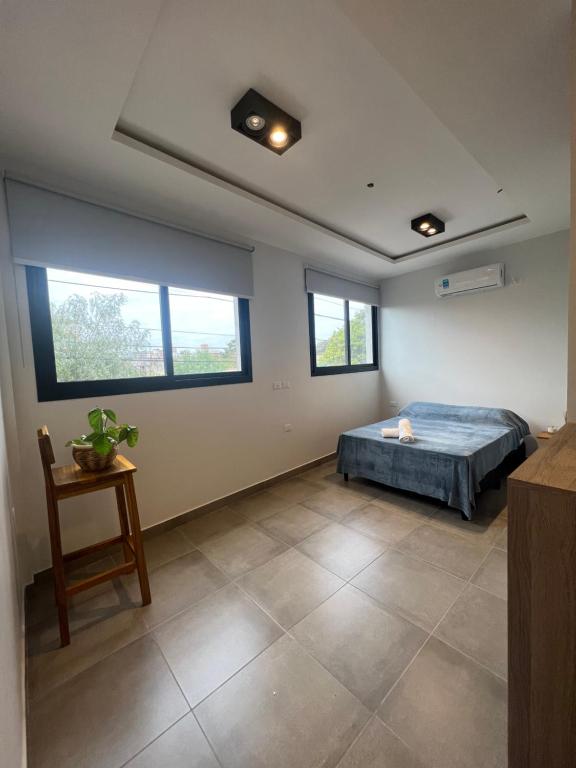 1 dormitorio con cama, mesa y ventanas en MONOAMBIENTE PARA 2 PERSONAS, EXCELENTE UBICACIONn en Santiago del Estero