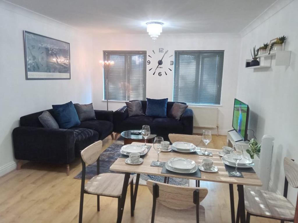 een woonkamer met een tafel en een bank bij Heronsgate GH015 in Gravesend