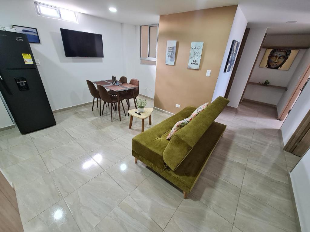 sala de estar con sofá verde y mesa en Apartamento Completo Ibague - Parqueadero - Ocobo, en Ibagué