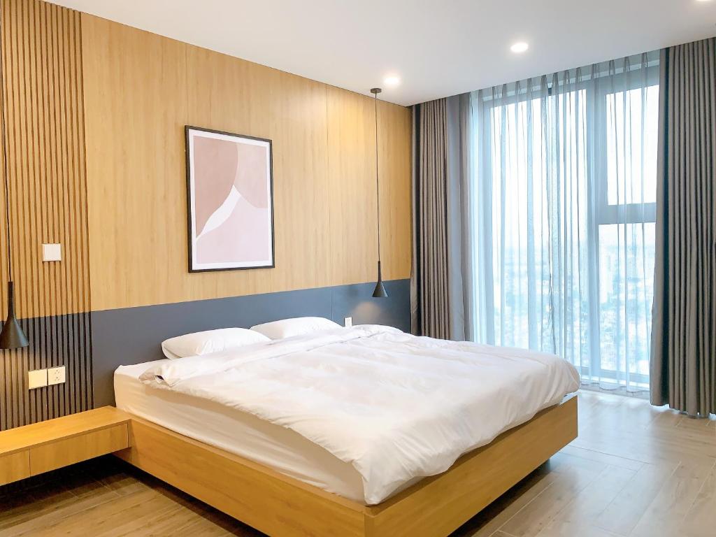 a bedroom with a large bed and a large window at TSQ STAY Hotel Apartment in Hanoi