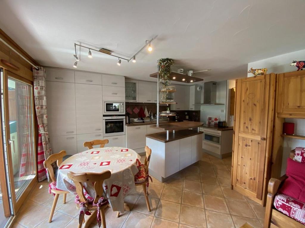 une cuisine avec une table et quelques chaises dans une pièce dans l'établissement Appartement 6 pers. avec piscine chauffée, grande terrasse, parking, Crest-Voland - FR-1-733-139, à Crest-Voland