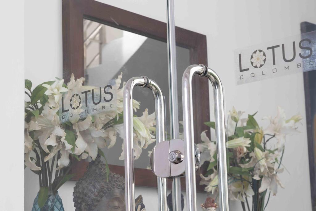 a mirror with a bunch of flowers in a vase at Lotus Colombo Guesthouse in Colombo