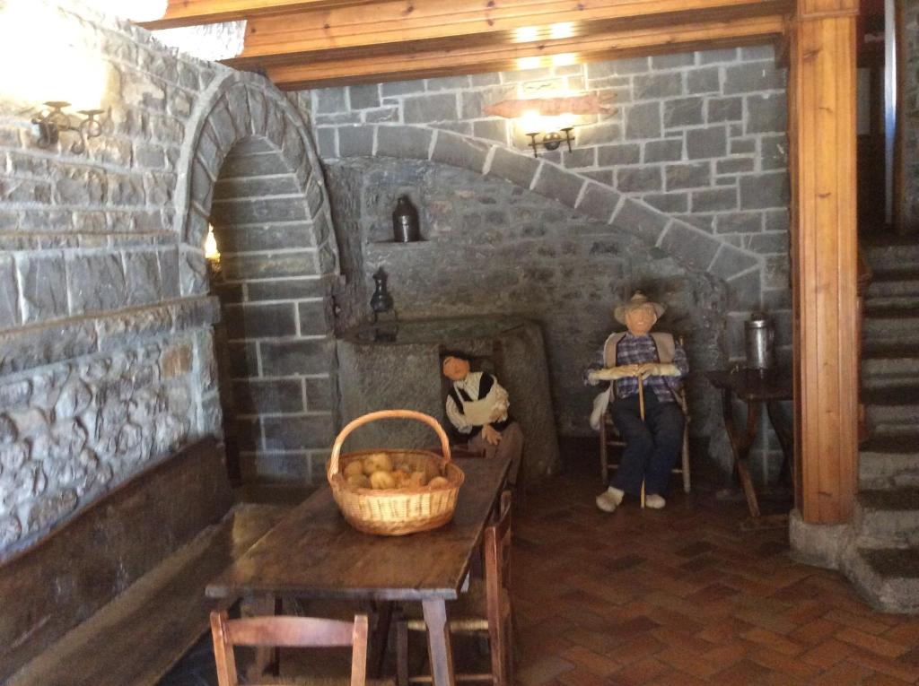 Una habitación con un horno de ladrillo con dos muñecas. en Fonda Carrera, en Labuerda