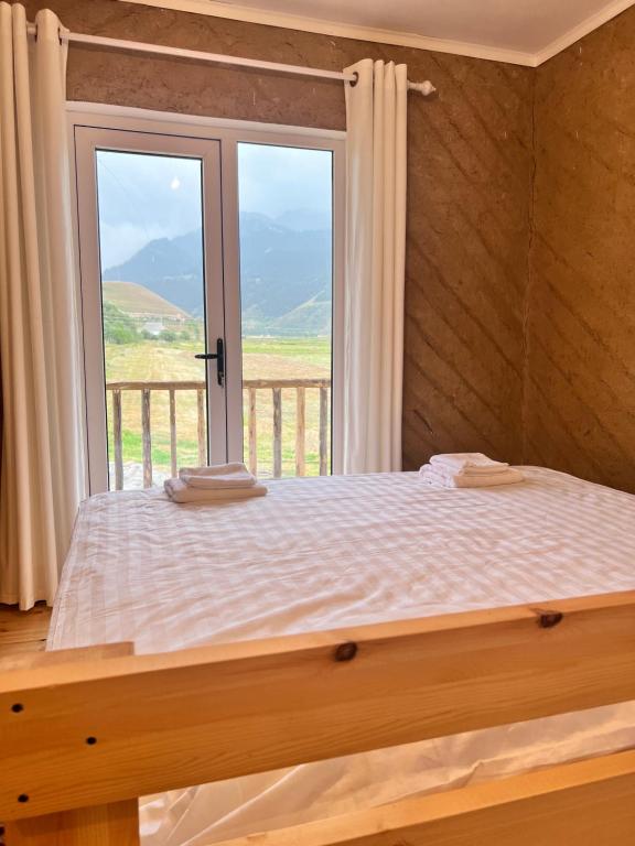 Schlafzimmer mit einem Bett und einem Fenster mit Aussicht in der Unterkunft Altay Village Hotel 