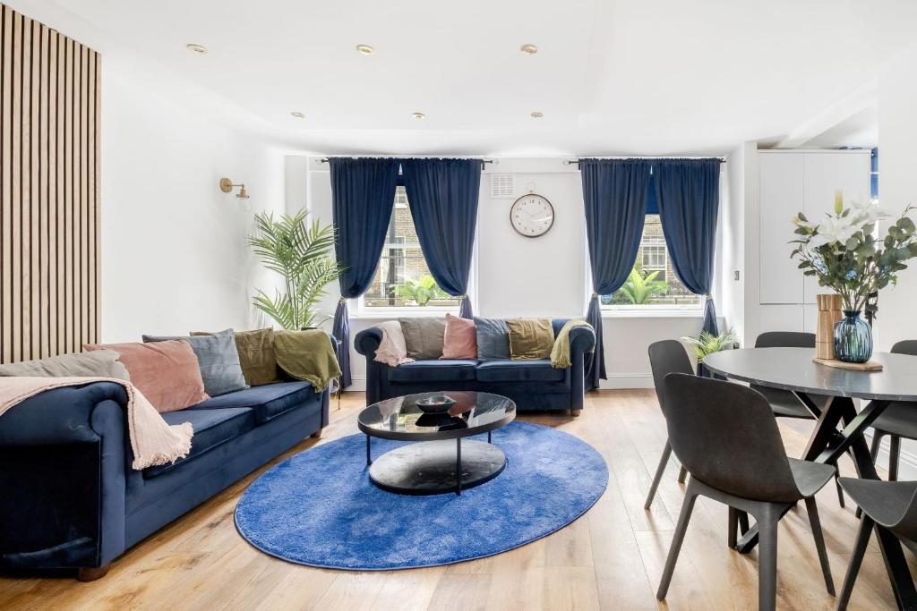 ein Wohnzimmer mit einem blauen Sofa und einem Tisch in der Unterkunft First Class Living Experience Luxury In Harley St in London
