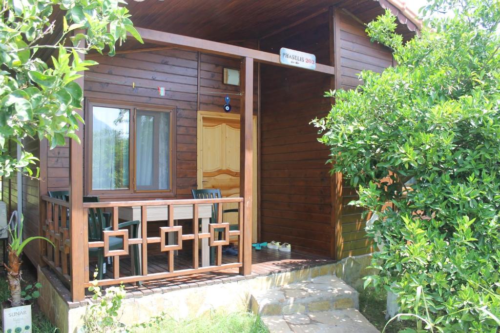 a small wooden cabin with a door and a porch at Merhaba Hotel in Cıralı