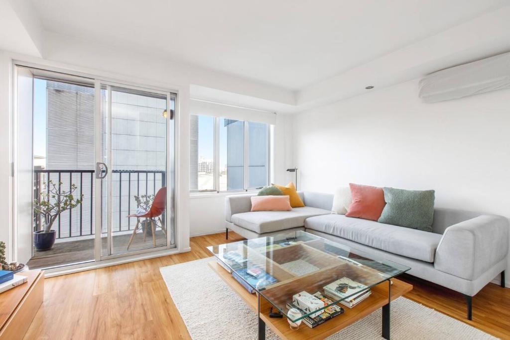 a living room with a couch and a glass table at 'Melbourne Chic on Russell' Cosy City Living in Melbourne