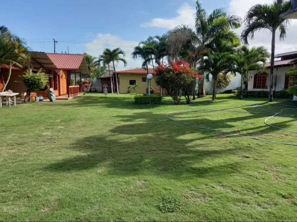 a yard with a hose in front of a house at Hosteria SR in Pedernales