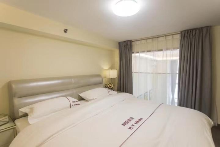 Postel nebo postele na pokoji v ubytování B T Miele Executive Apartment - Qianhai Square Shenzhen