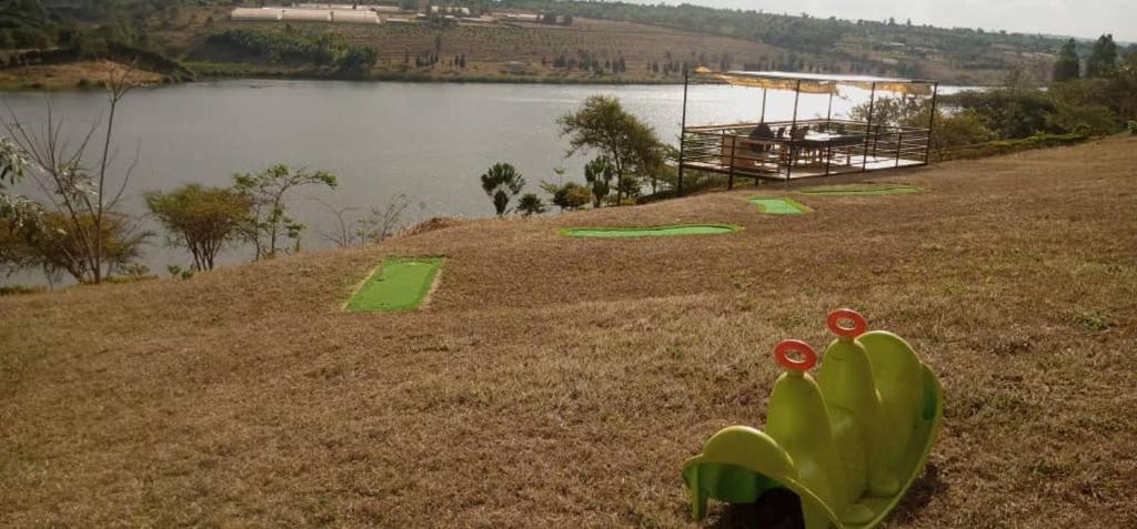 a field with green frisbees on it next to a lake at SUGIRA ECO-RESORT in Rwamagana