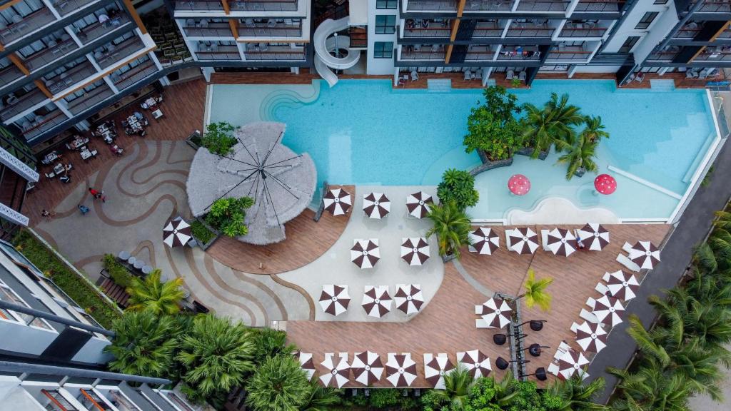 uma vista superior de uma piscina com um guarda-sol em Sea Seeker Krabi Resort - SHA Extra Plus em Praia de Aonang