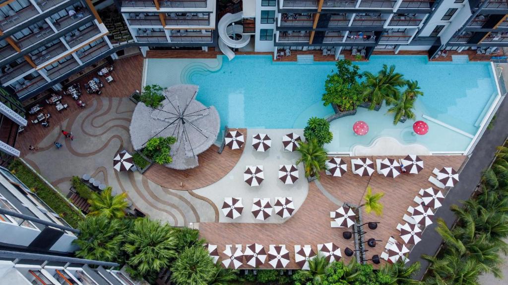 Sea Seeker Krabi Resort - SHA Extra Plus في شاطيء آونانغ: اطلالة علوية على مسبح مع مظلة