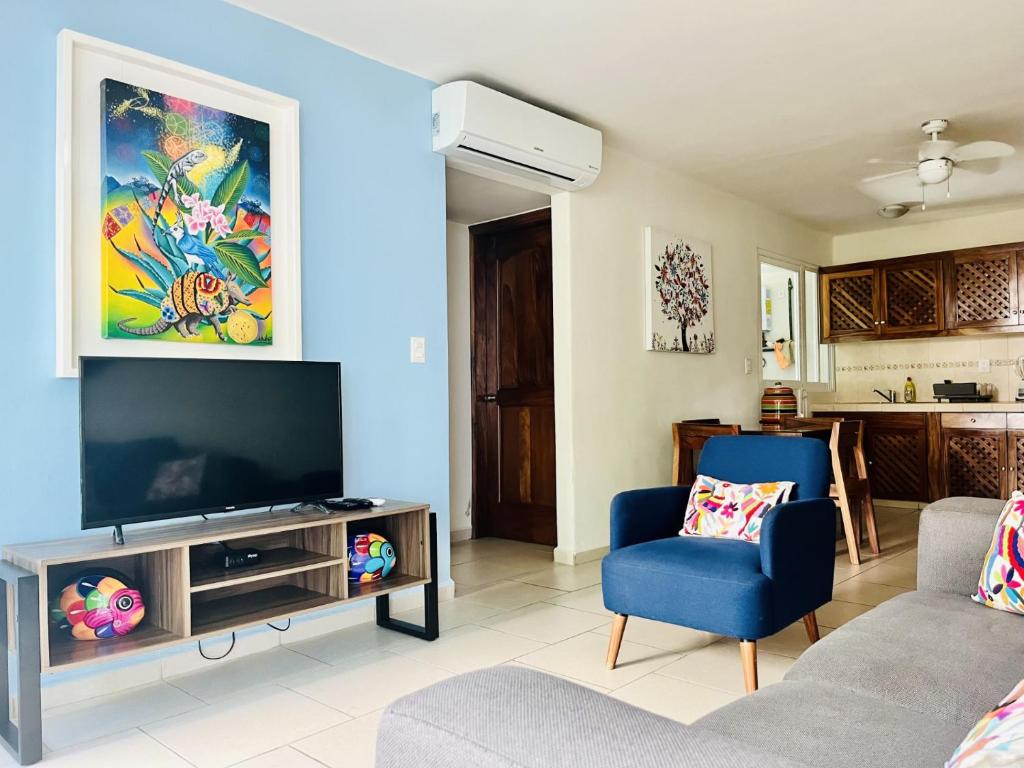 uma sala de estar com uma televisão de ecrã plano e 2 cadeiras em El Colorín, a condo in the heart of Huatulco em Santa Cruz Huatulco