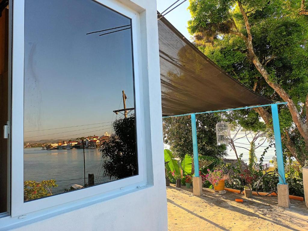 una ventana de una casa con vistas al agua en Casa Zoila Hospedaje frente al lago Lakefront lodging en Flores
