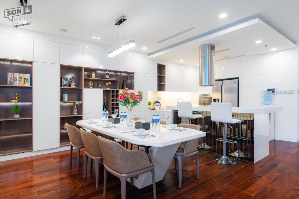 a dining room with a white table and chairs at VINCOM Center Đồng Khởi District 1 in Ho Chi Minh City