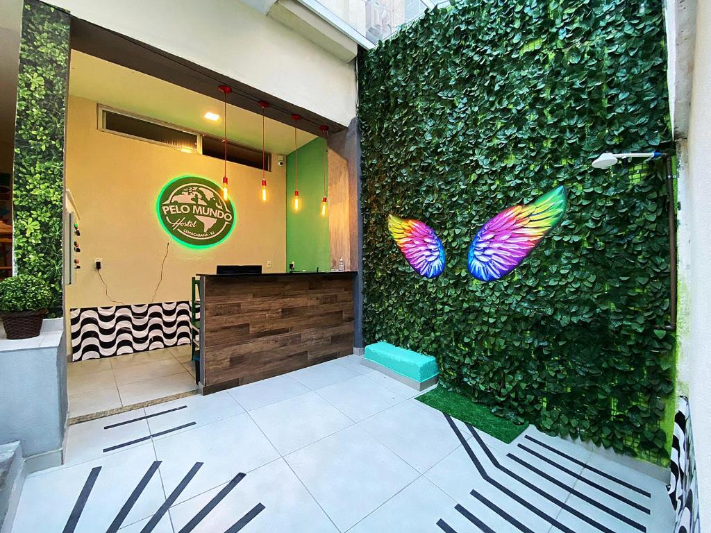 un restaurante con una pared verde con mariposas. en Hostel Pelo Mundo, en Río de Janeiro