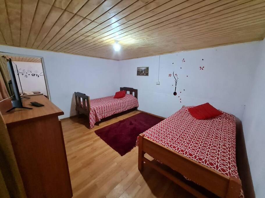 a room with two beds and a television in it at Arriendo Los Vilos, Central in Los Vilos