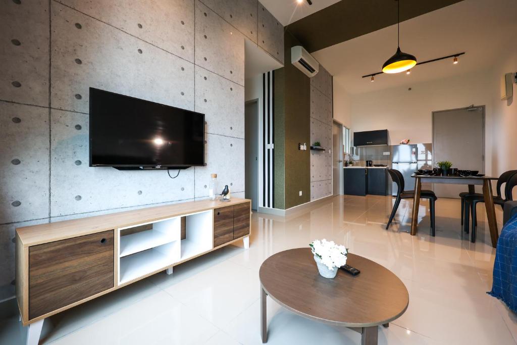 a living room with a flat screen tv on a wall at Amber Cove Melaka Icon stay in Melaka